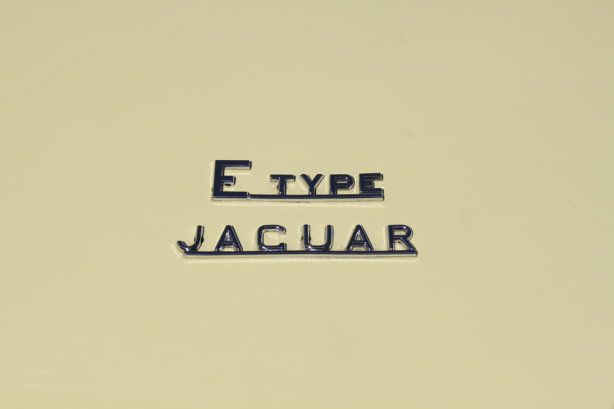 Chrome 'E TYPE' and 'JAGUAR' script on a cream boot lid. Opens a larger view