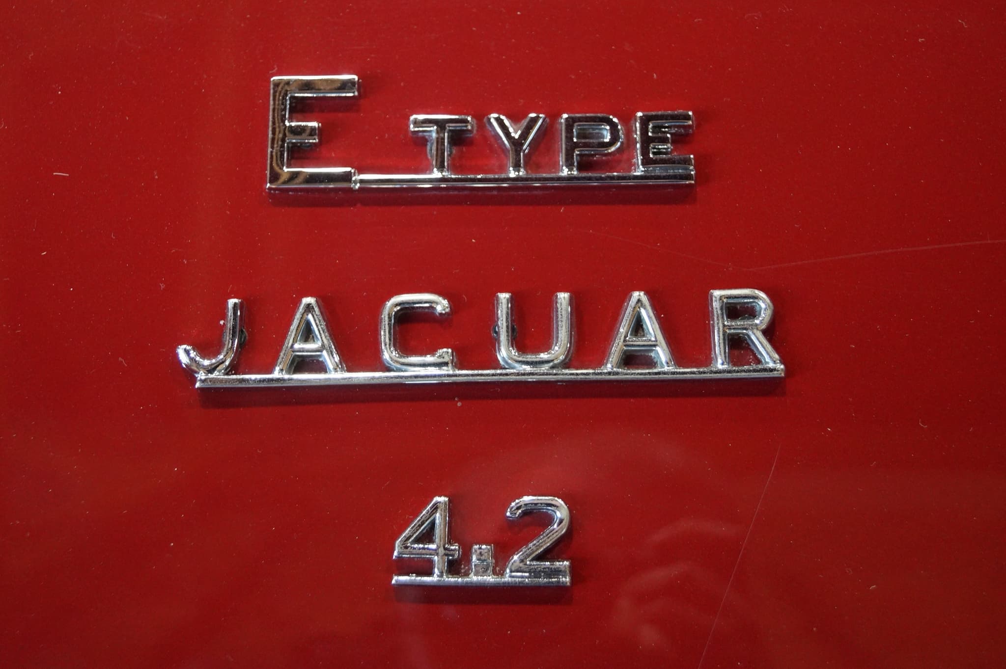 Chrome 'E TYPE', 'JAGUAR' and '4.2' script on a red boot lid. Opens a larger view